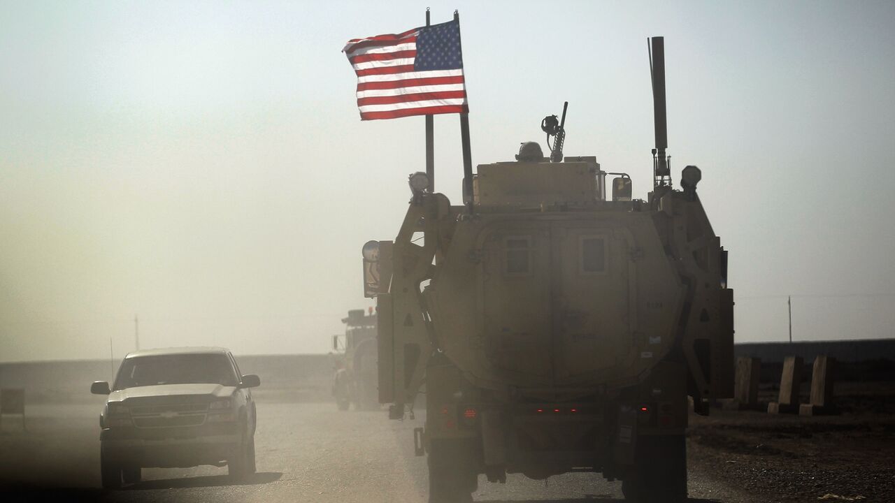 A US Army armored vehicle flies an American flag as it provides security escort for a convoy of vehicles pulling equipment that is heading to Kuwait from Camp Adder as the Army continues to send it's soldiers and equipment home and the base is prepared to be handed back to the Iraqi government later this month on December 2, 2011, at Camp Adder, near Nasiriyah, Iraq.